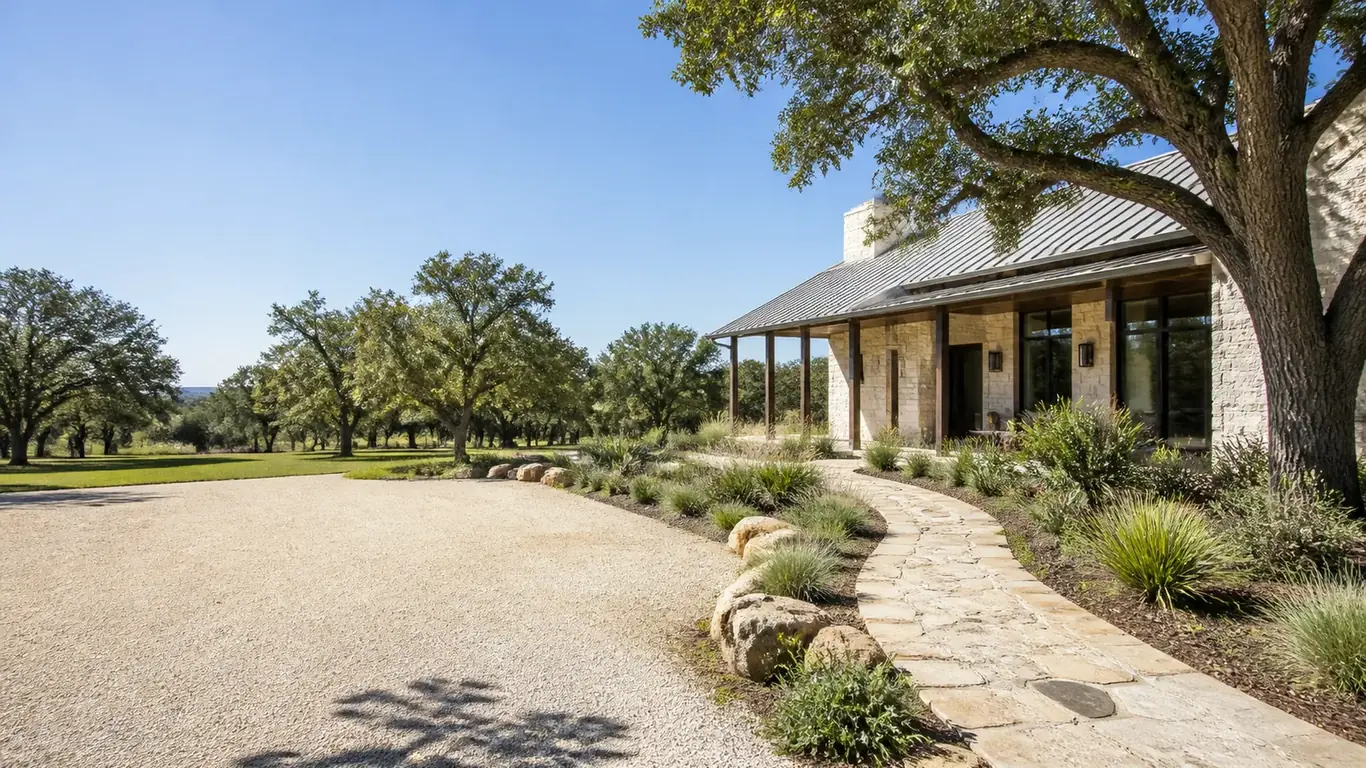 Illustration: Stone ranch house with a metal roof and a flagstone path across a gravel drive under live oaks