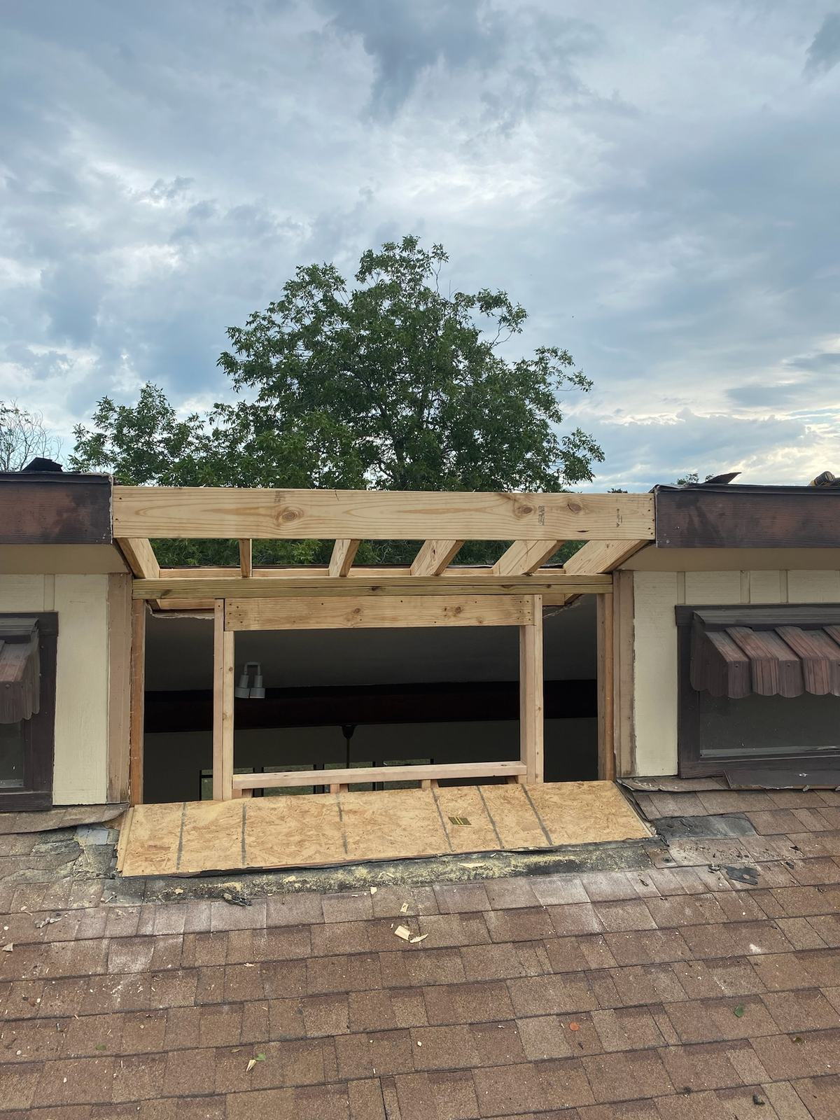 New framed opening and header built into a roofline between two existing windows