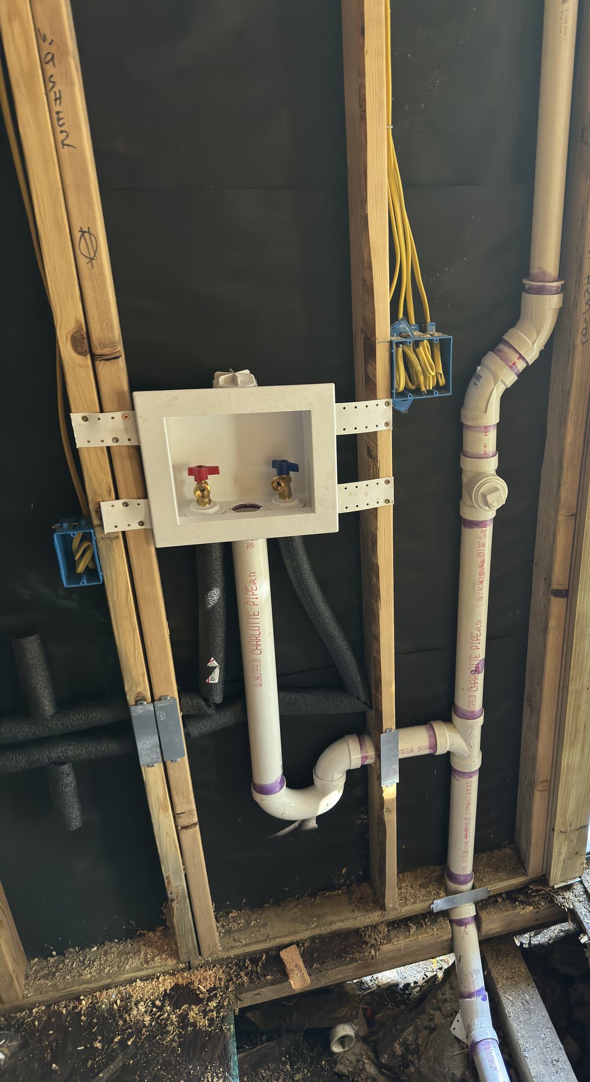 Laundry rough-in with a washer outlet box, PVC trap, drain and vent in an open stud wall
