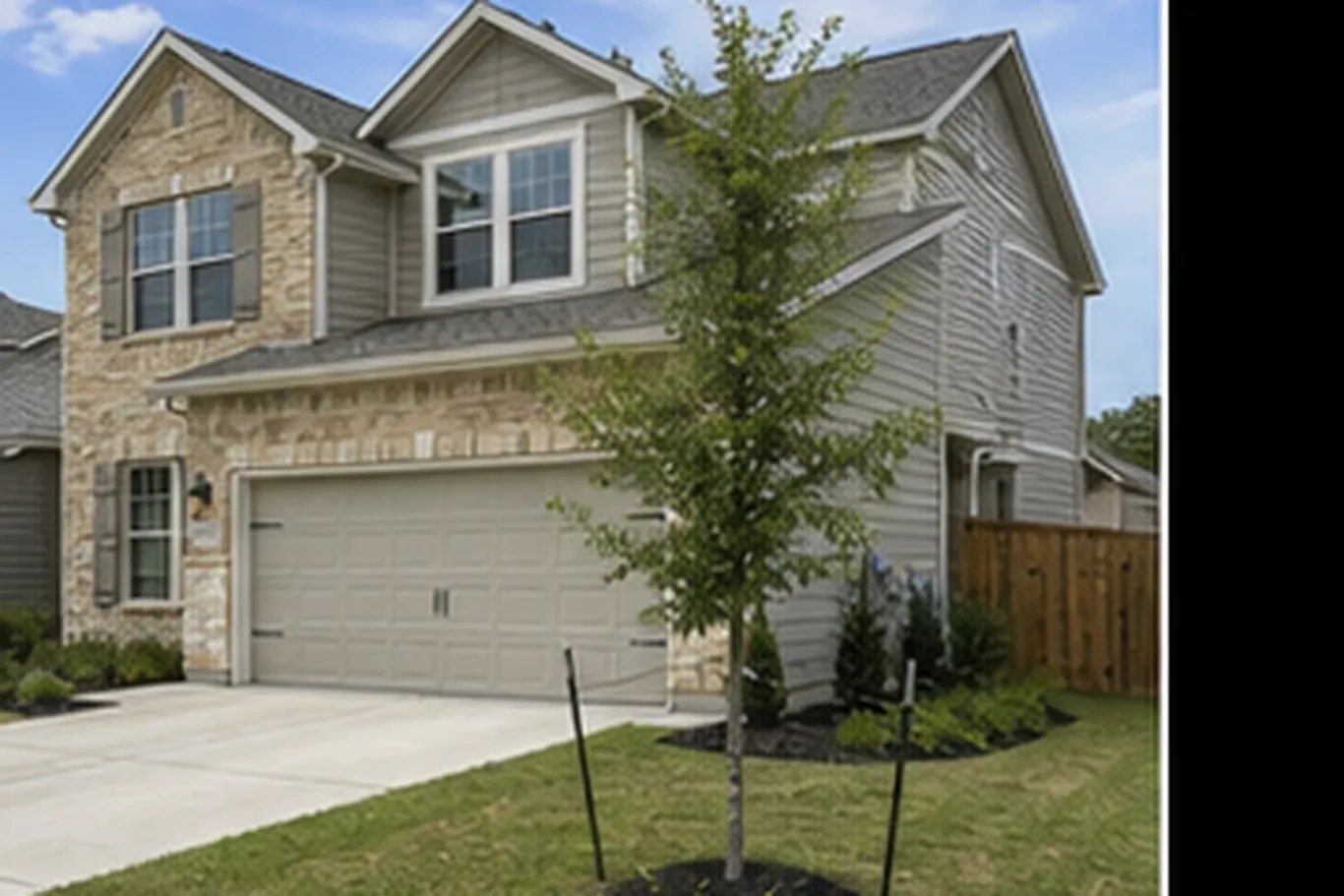 Two-storey San Antonio stone-and-siding house with a two-car garage, new lawn and street tree
